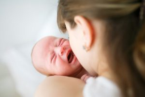 Bebé llorando en brazos de su madre